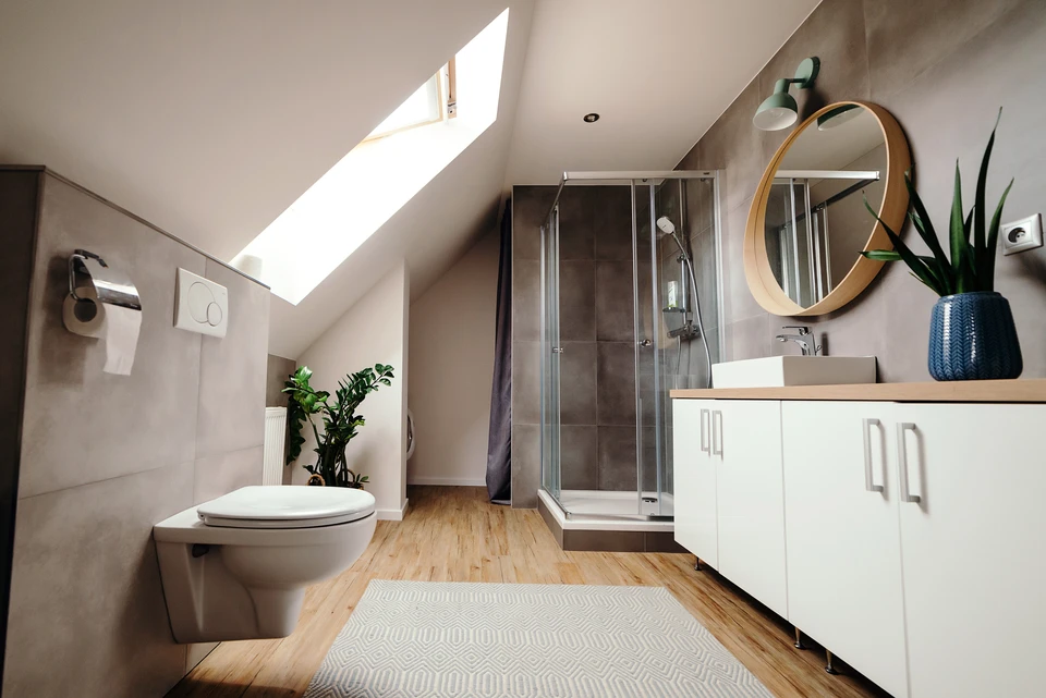 Salle de bain moderne sous combles avec douche &agrave; l'italienne, WC suspendu et meuble vasque blanc