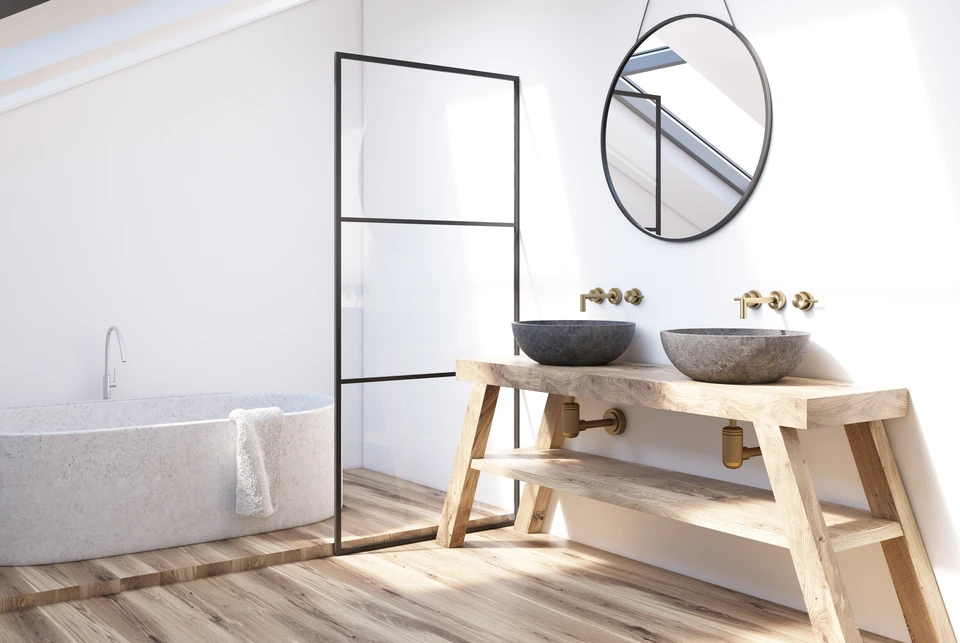 Int&eacute;rieur moderne de la salle de bains avec une tablette en bois, deux lavabos, un miroir rond et une baignoire