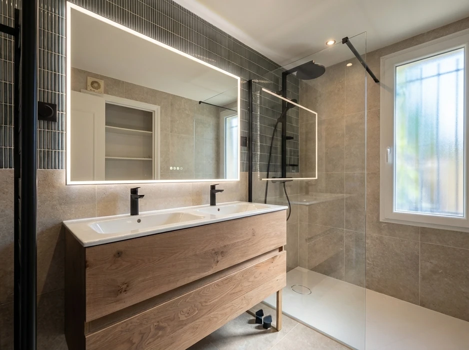 Salle de bain moderne avec double vasque encastrée sur meuble suspendu en bois chêne, robinetterie noire mate, grand miroir LED rétroéclairé