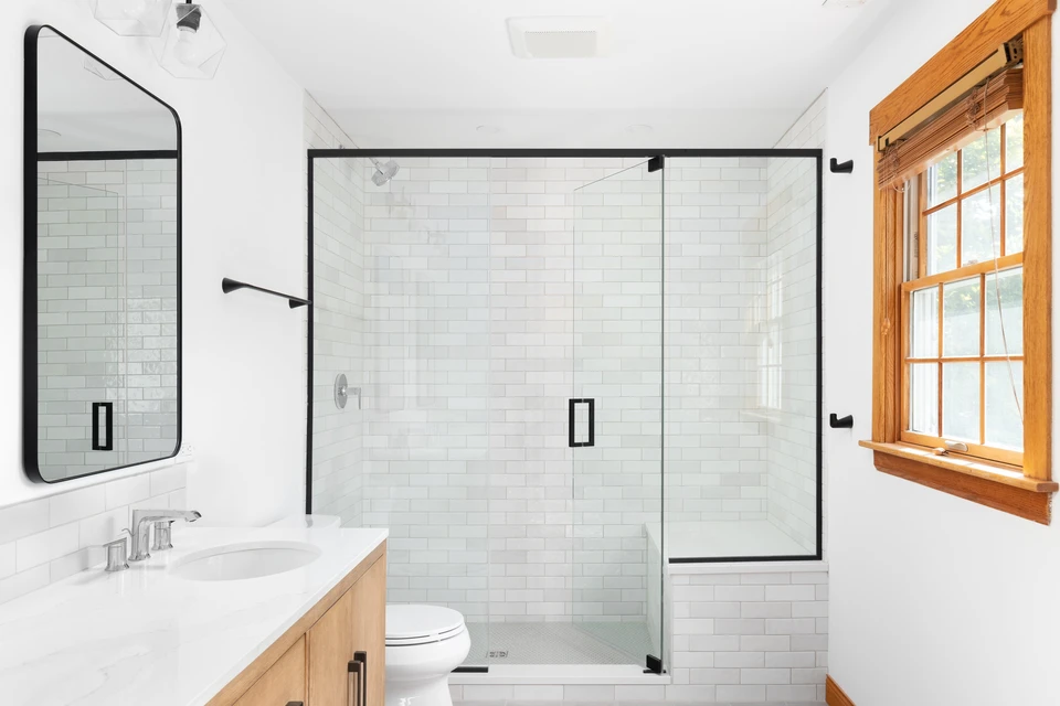 Salle de bain moderne avec douche à l'italienne, carrelage métro blanc, verrerie noire mat