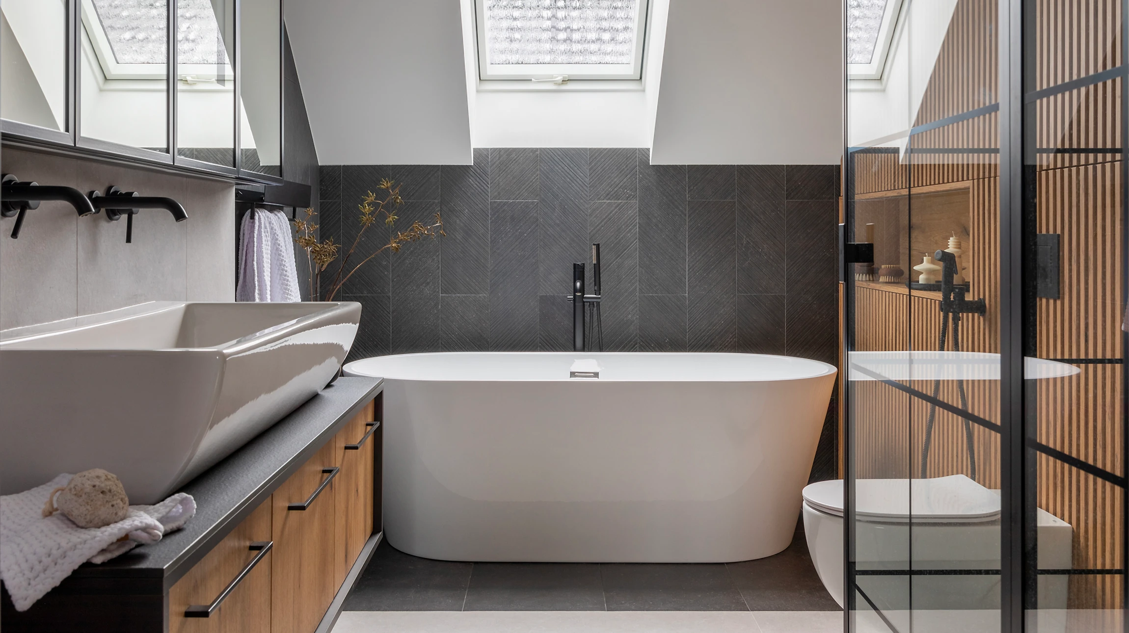 Salle de bain moderne avec double vasque blanche pos&eacute;e sur meuble suspendu en bois naturel &agrave; fa&ccedil;ade cannel&eacute;e